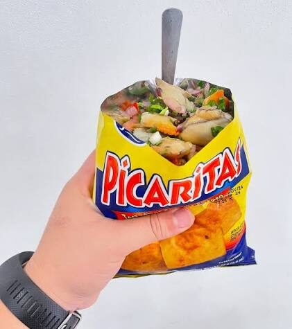A Picaritas chip bag filled with fresh ceviche and seafood — the classic Costa Rican caldosa street snack at Jaco Beach
