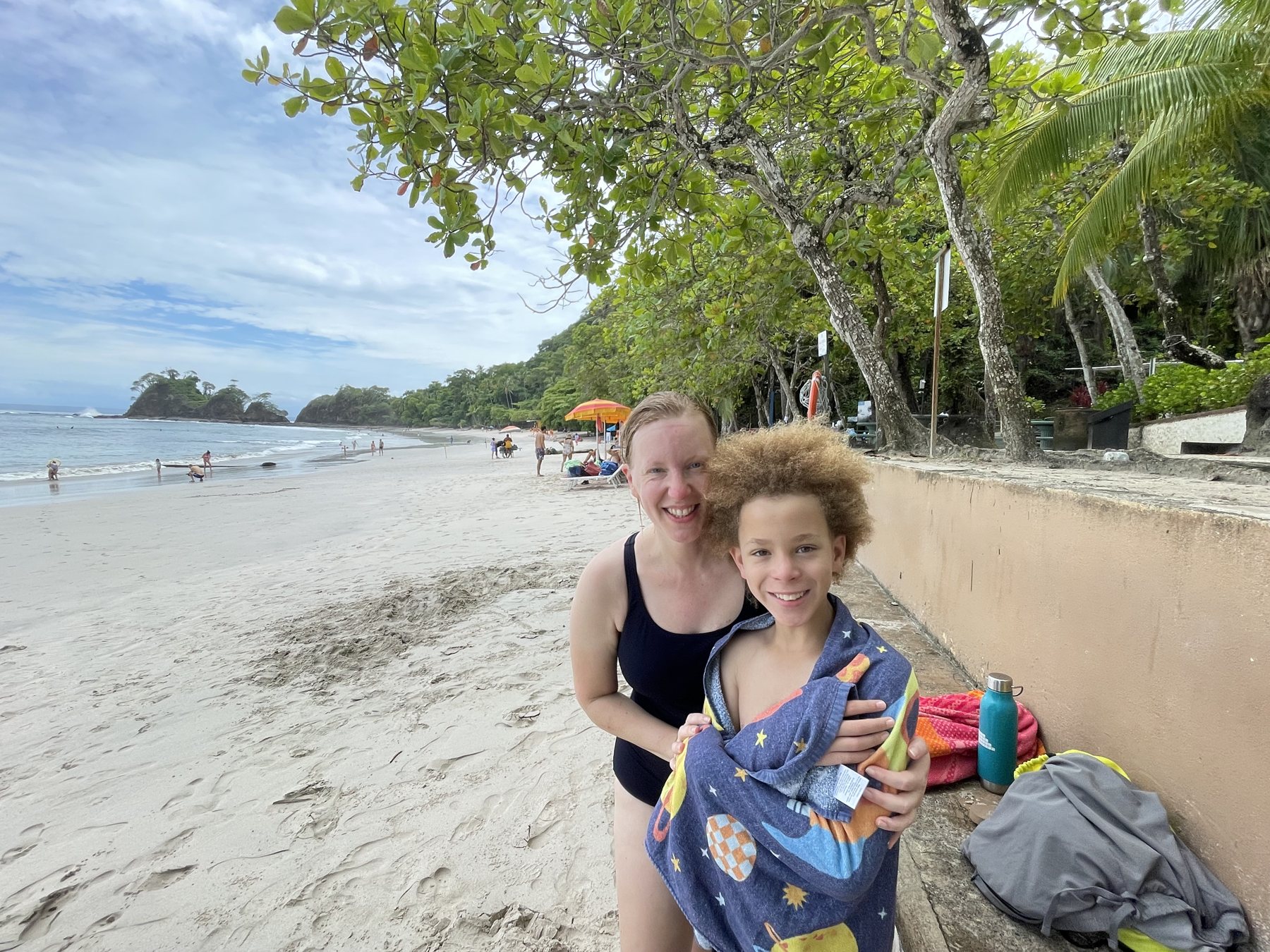 A family enjoying the white-sand beach near the Punta Leona building lot — best properties near Jaco Beach, Costa Rica
