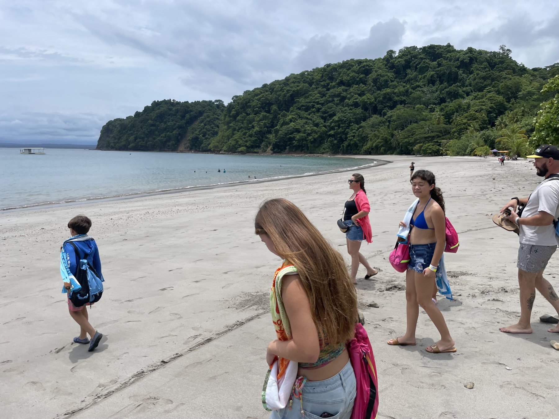 A group enjoying the wide white-sand beach near the lot on the road to Playa Mantas — best properties near Jaco Beach