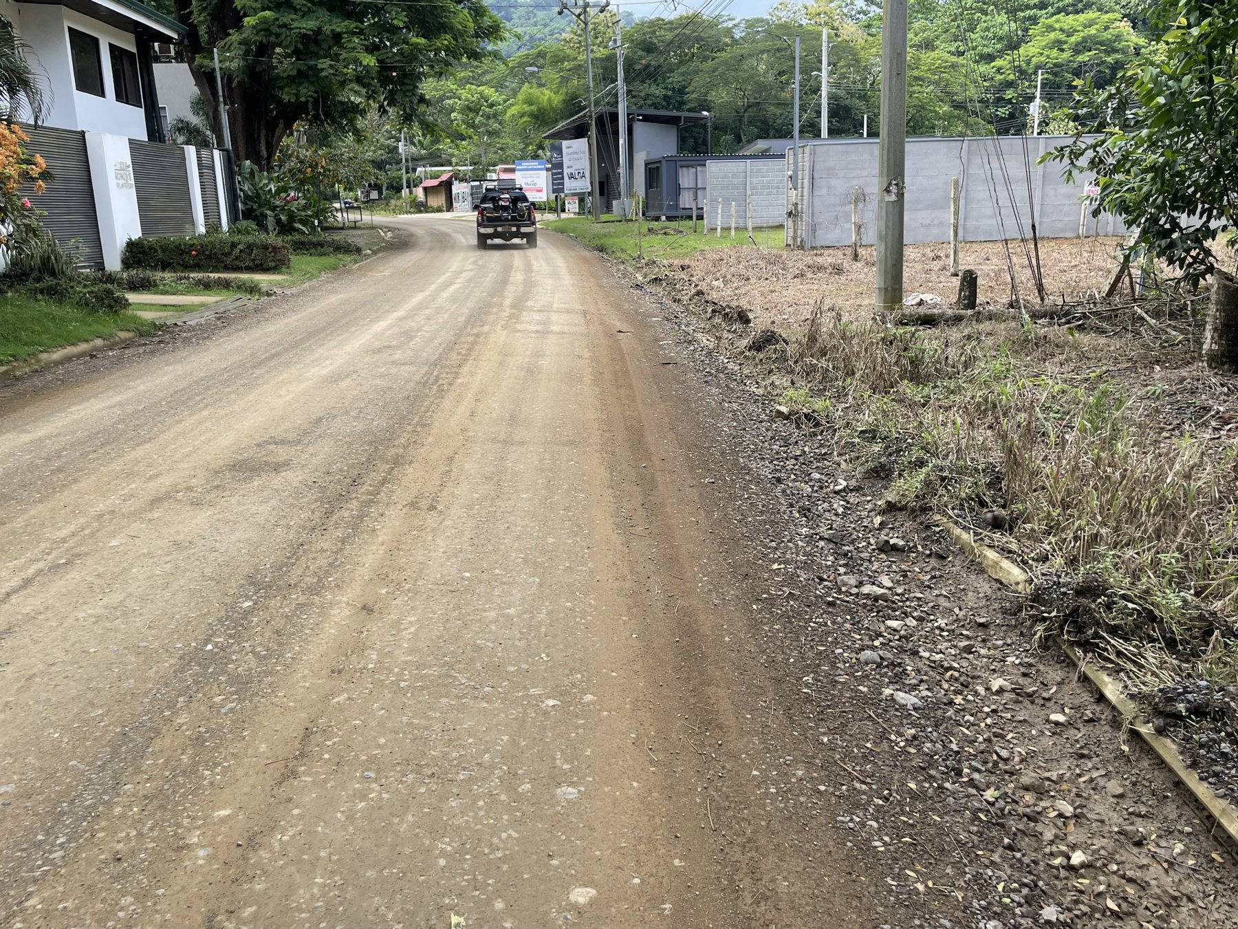 The quiet neighborhood road leading to the 333 m² building lot near Playa Mantas, with homes and utilities already in place — Punta Leona real estate