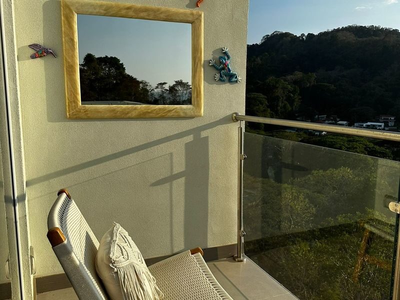 Private balcony with hammock and glass railing overlooking green mountains near Punta Leona — Jaco Beach real estate, best priced real estate near Jaco