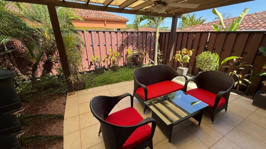 Private terrace with rattan seating and tropical garden at Villa Sitio de Ensueno — gated villa community near Punta Leona, Jaco Beach real estate