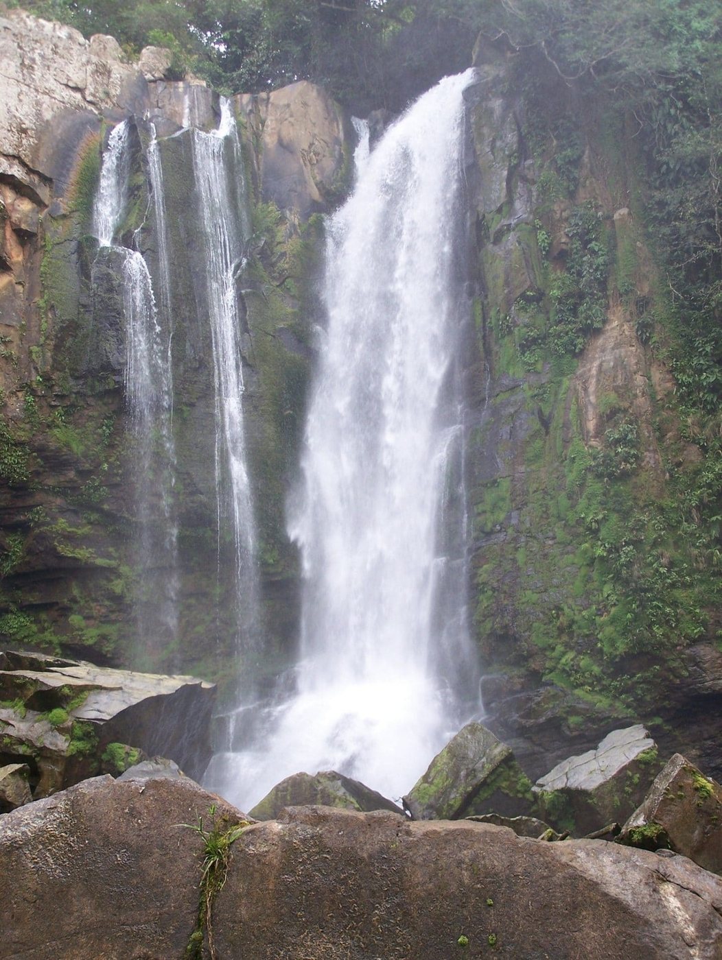Twin jungle waterfalls cascading into a pool